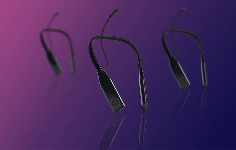 Trys identiški kaklo įrenginiai plaukioja violetiniame fone su atspindžiais ant blizgaus paviršiaus