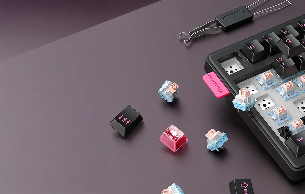 Black Onikuma keyboard with removed keys and switch replacement tool on dark background
