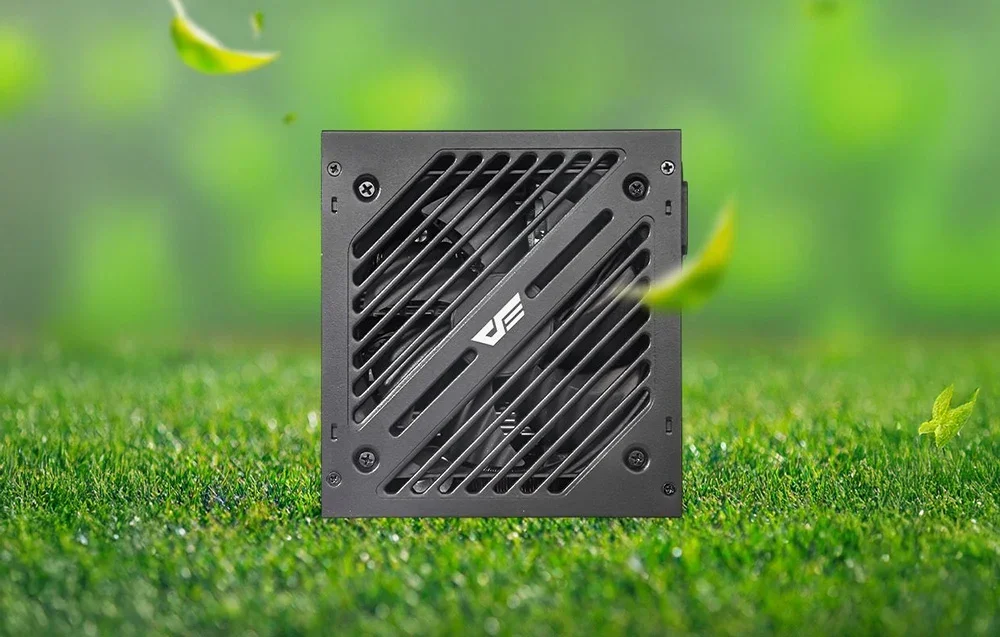 Juodo maitinimo bloko galinis skydelis su ventiliacijos grotele ir logotipu žalios žolės fone